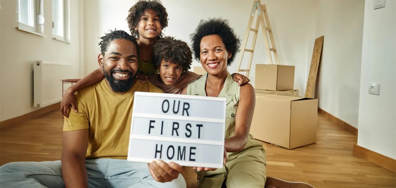 Family-with-our-first-home-sign-1300w620h-GettyImages-1513203533